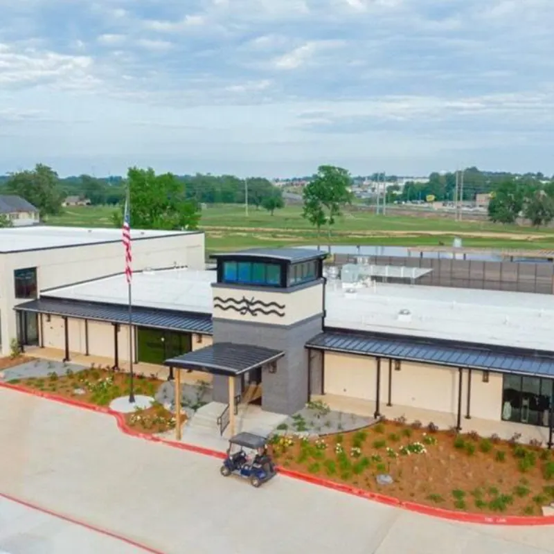 Aerial view of a hospitality and entertainment clubhouse with a landscaped entry